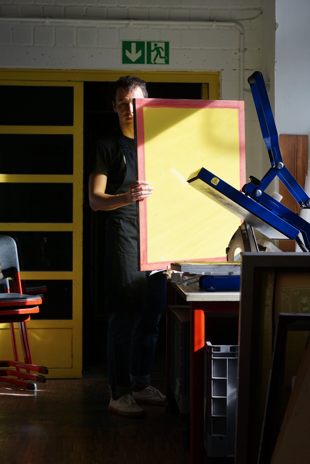 Artist holding a framed artwork in the studio